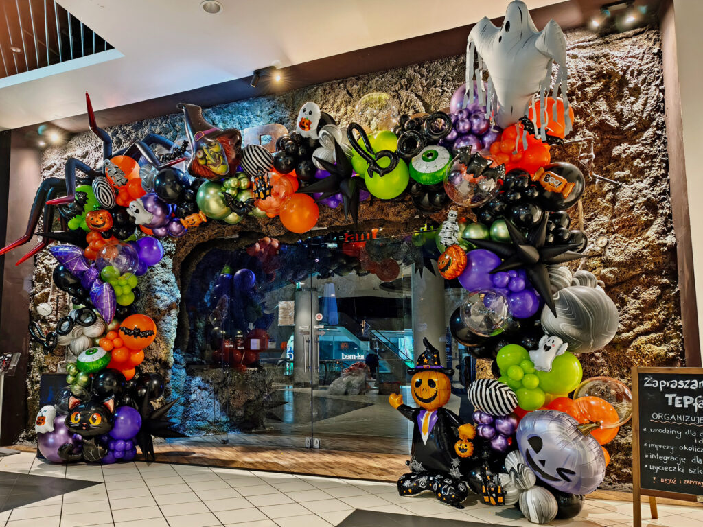 Wielokolorowa organiczna brama z balonów na Halloween jako dekoracja wejścia do centrum rozrywki TEPfactor w Warszawie.